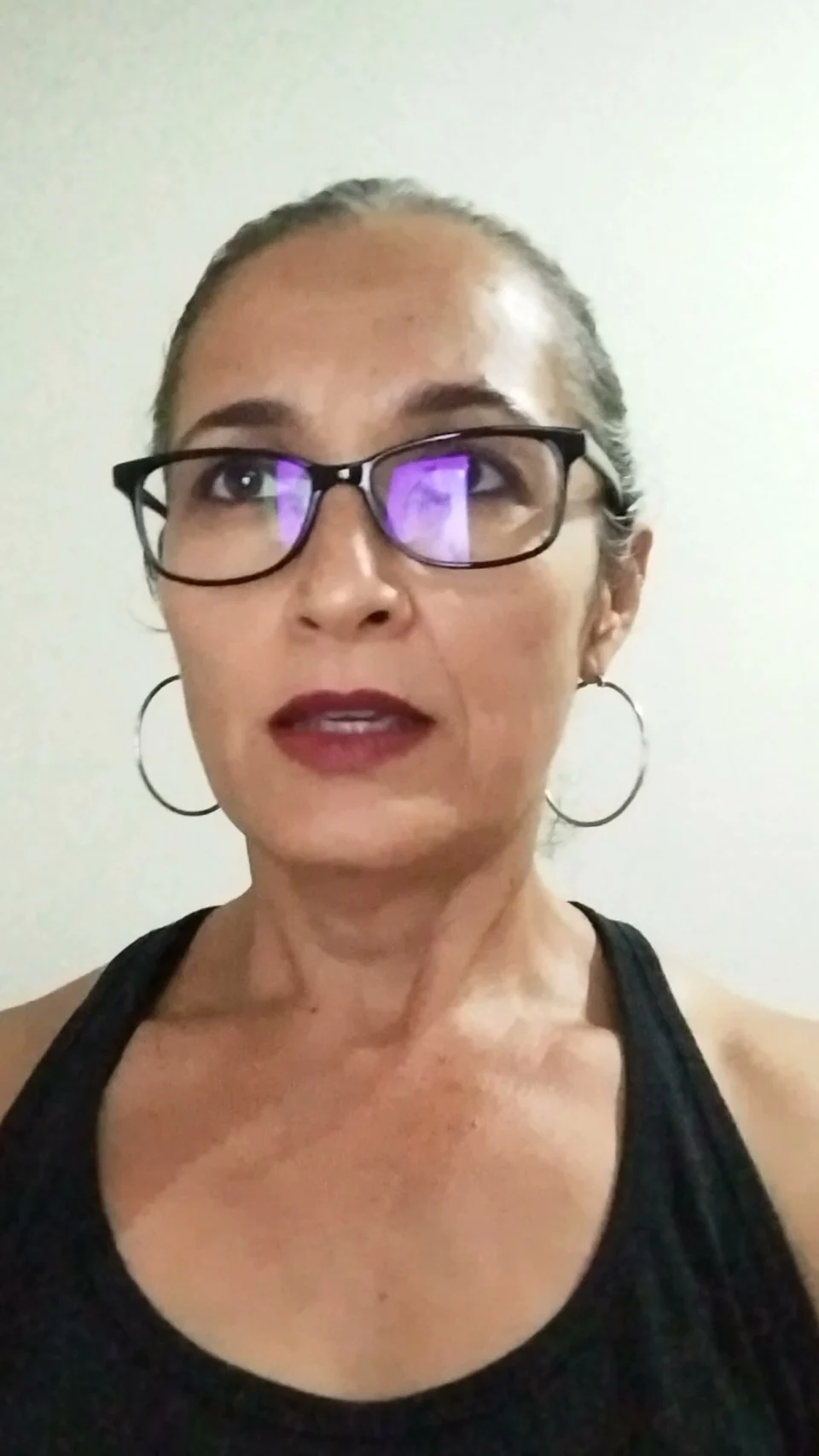 A woman wearing glasses during a recorded conversation