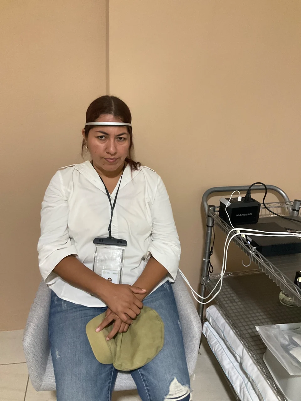 A seated person wearing an EEG headband in the research room